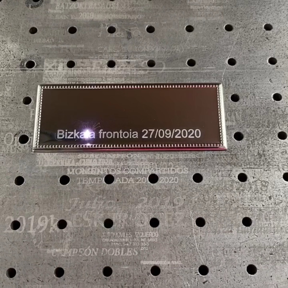 Placa reci&eacute;n grabada sobre la mesa del l&aacute;ser